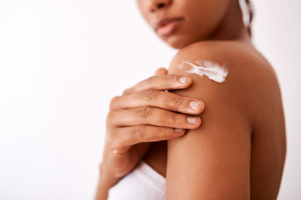 Patient applying moisturizer to skin