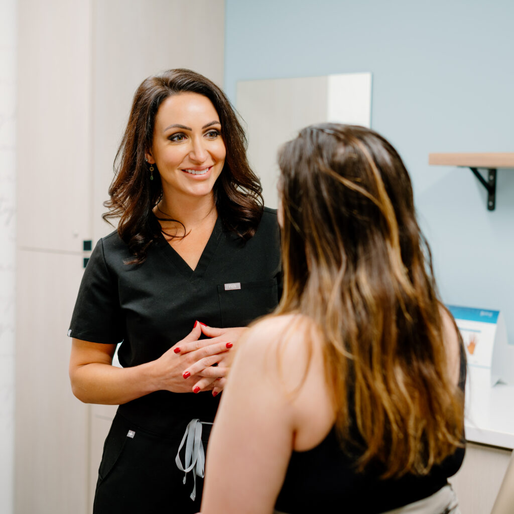 Adrienne Yanich discussing facial optimization with a patient