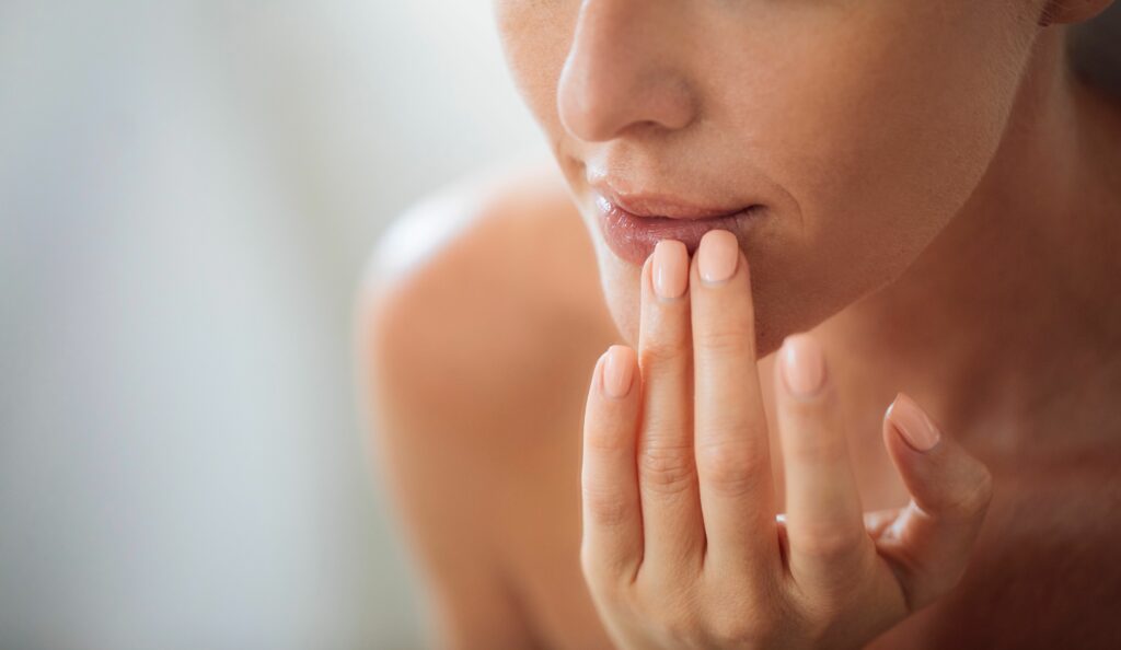 Patient performing lip injection aftercare