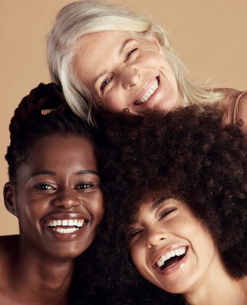 A group of happy face surgery patients, smiling in a muted setting
