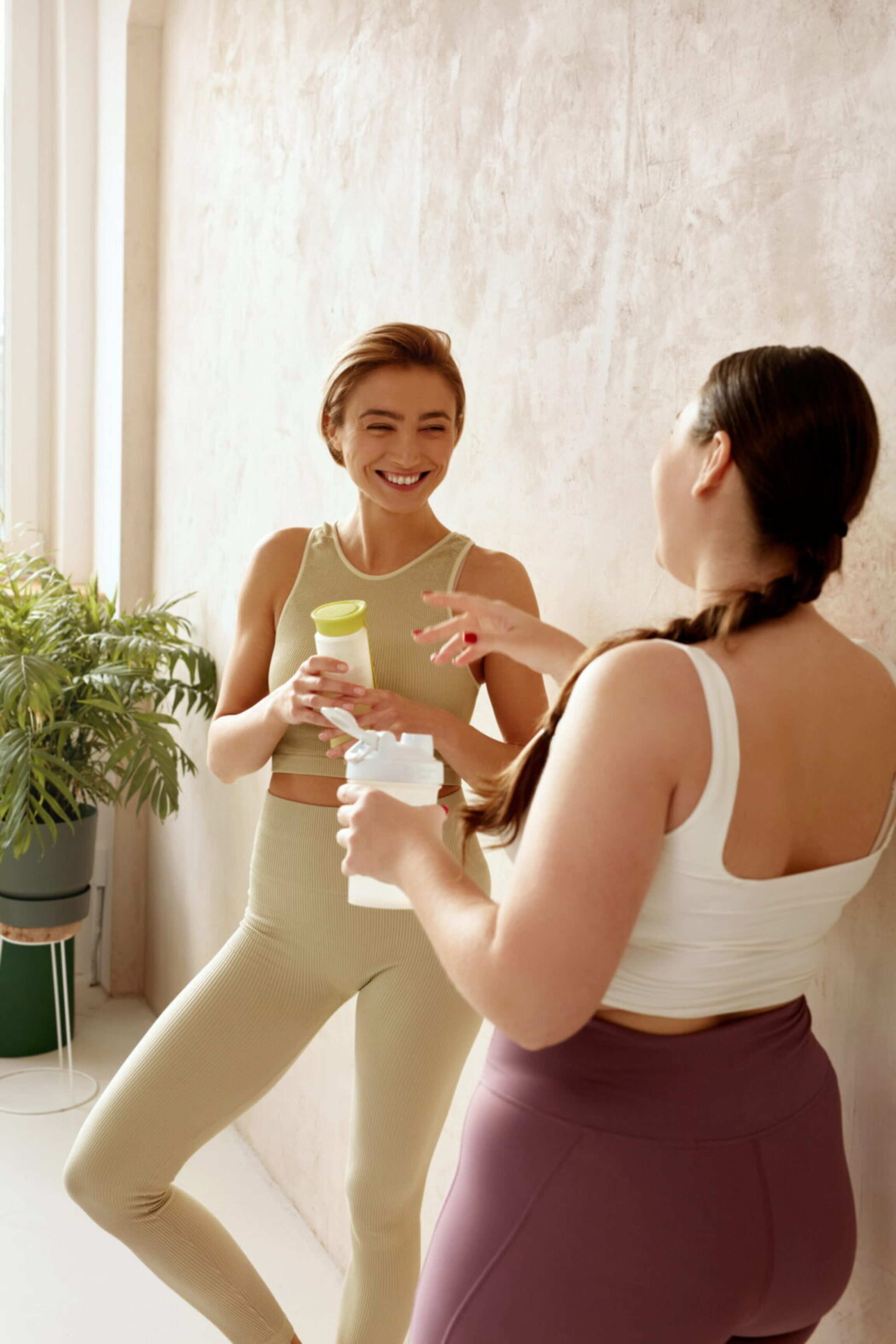 2 women patients discussing their exercise routines outside of the gym