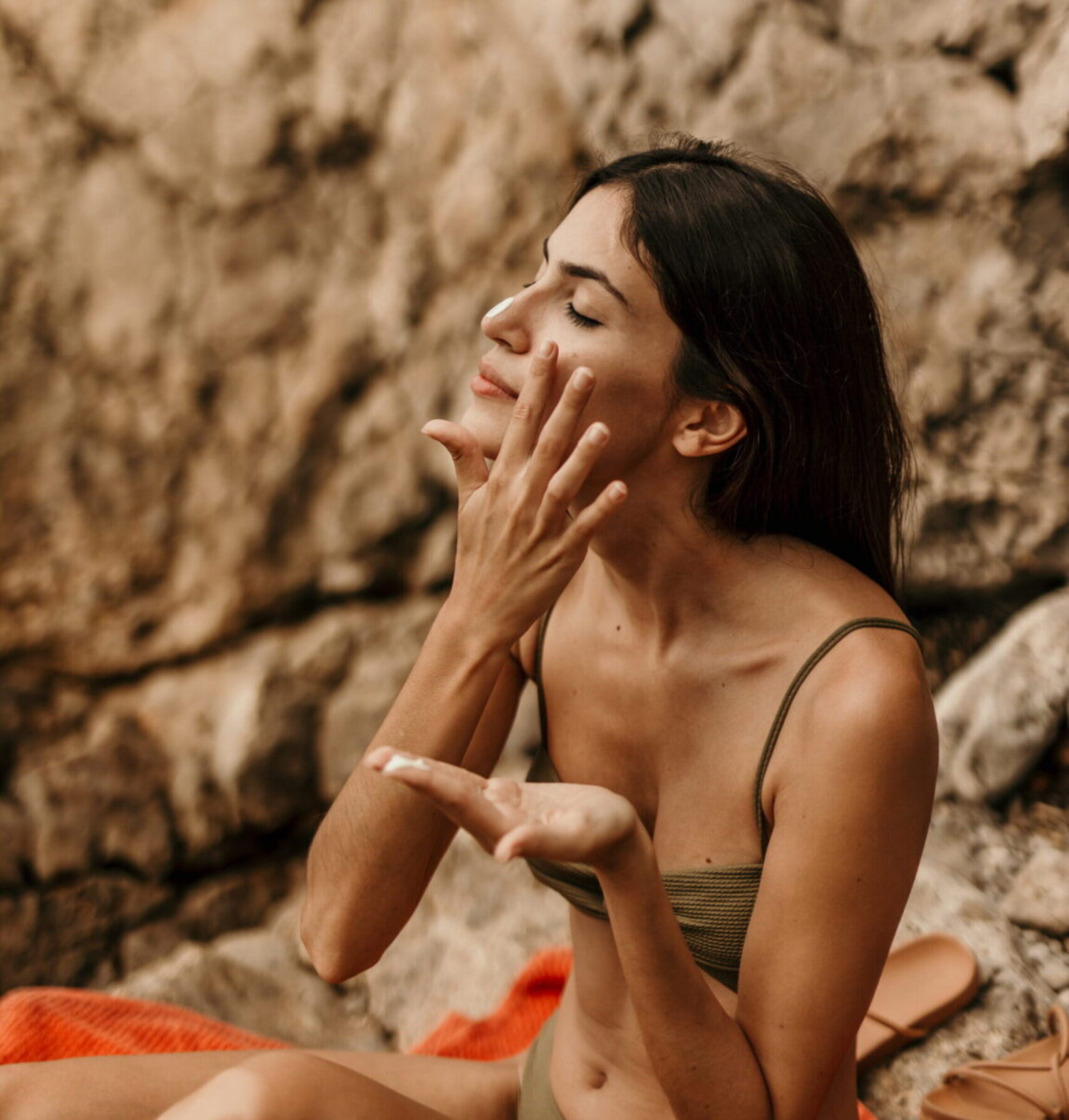 A younger patient with oily skin reapply spf after being in the sun at the beach