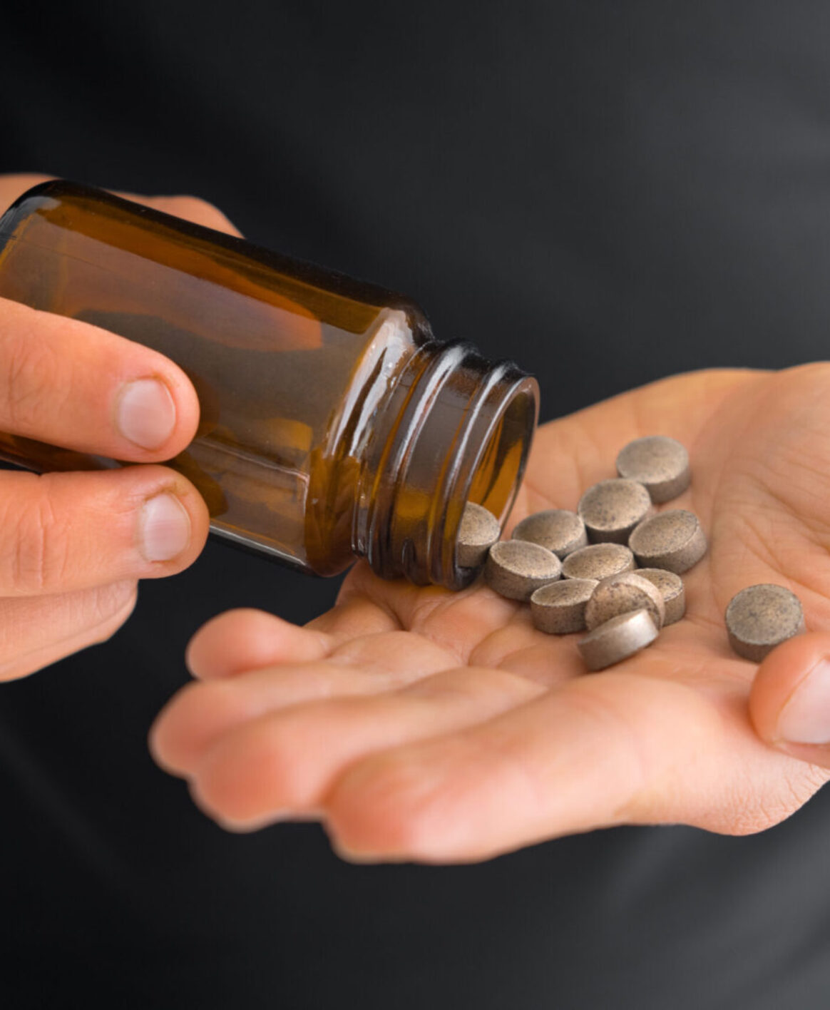 A close up photo of a patient counting their zinc tablets