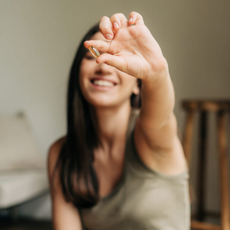 A patient holding up her vitamin c supplement she takes each morning