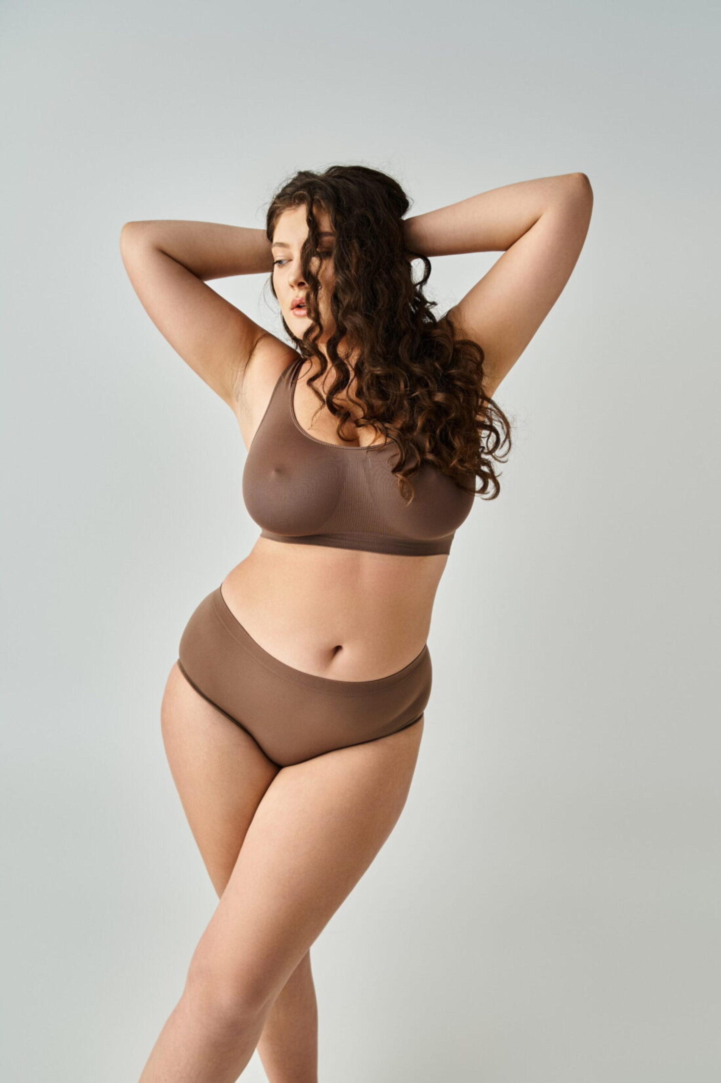 A Columbus, Ohio body contouring surgery patient confidently posing against a muted gray background