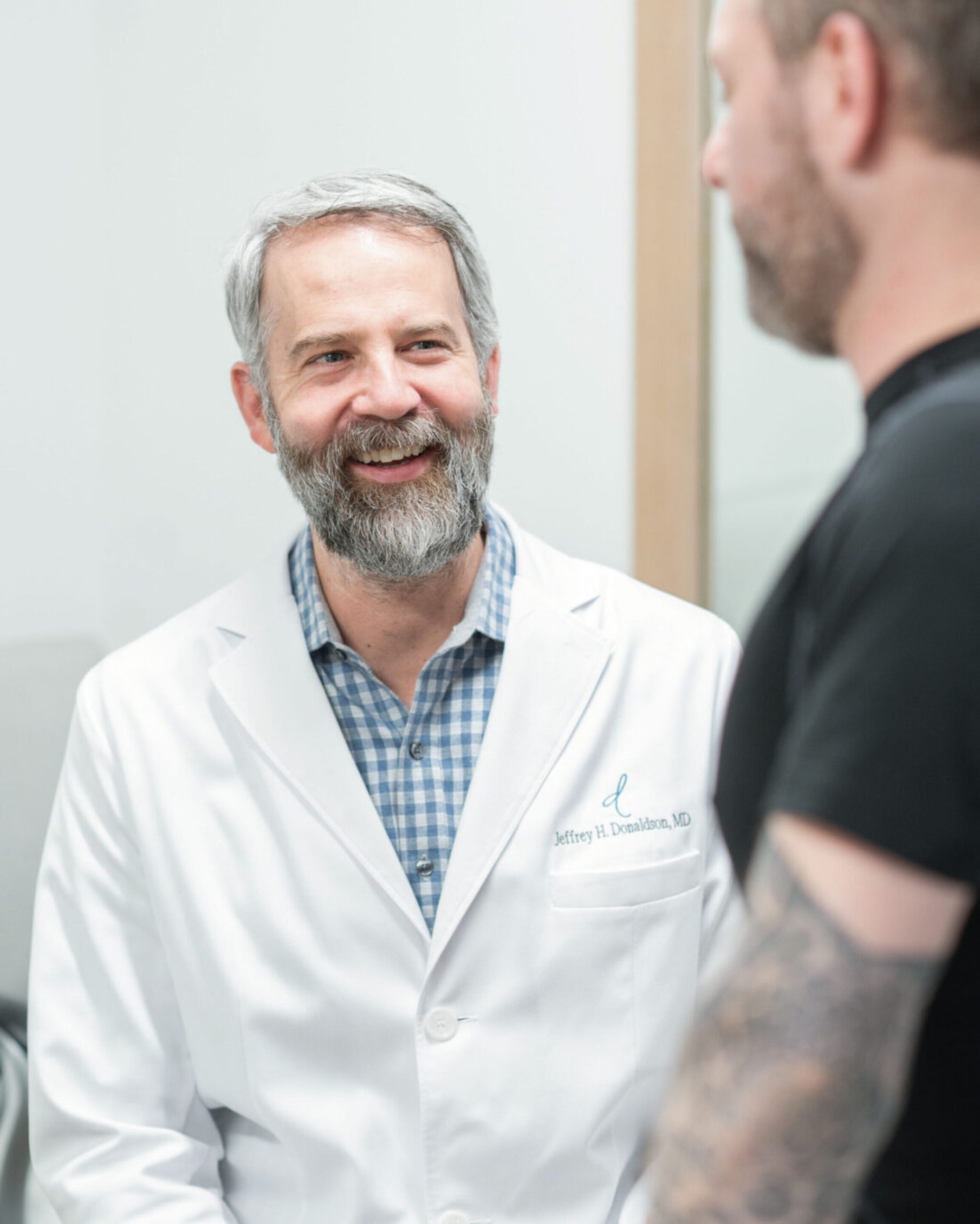 Dr. Donaldson discussing pre- and post-surgical plans with a male plastic surgery patient in the Dublin, Ohio office