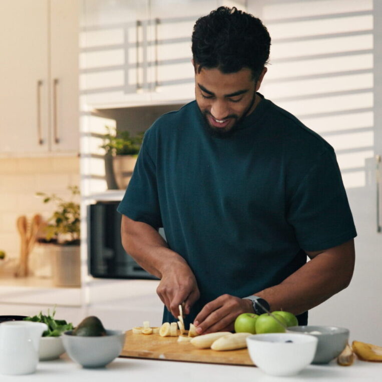 A younger functional medicine patient doing meal prep at home