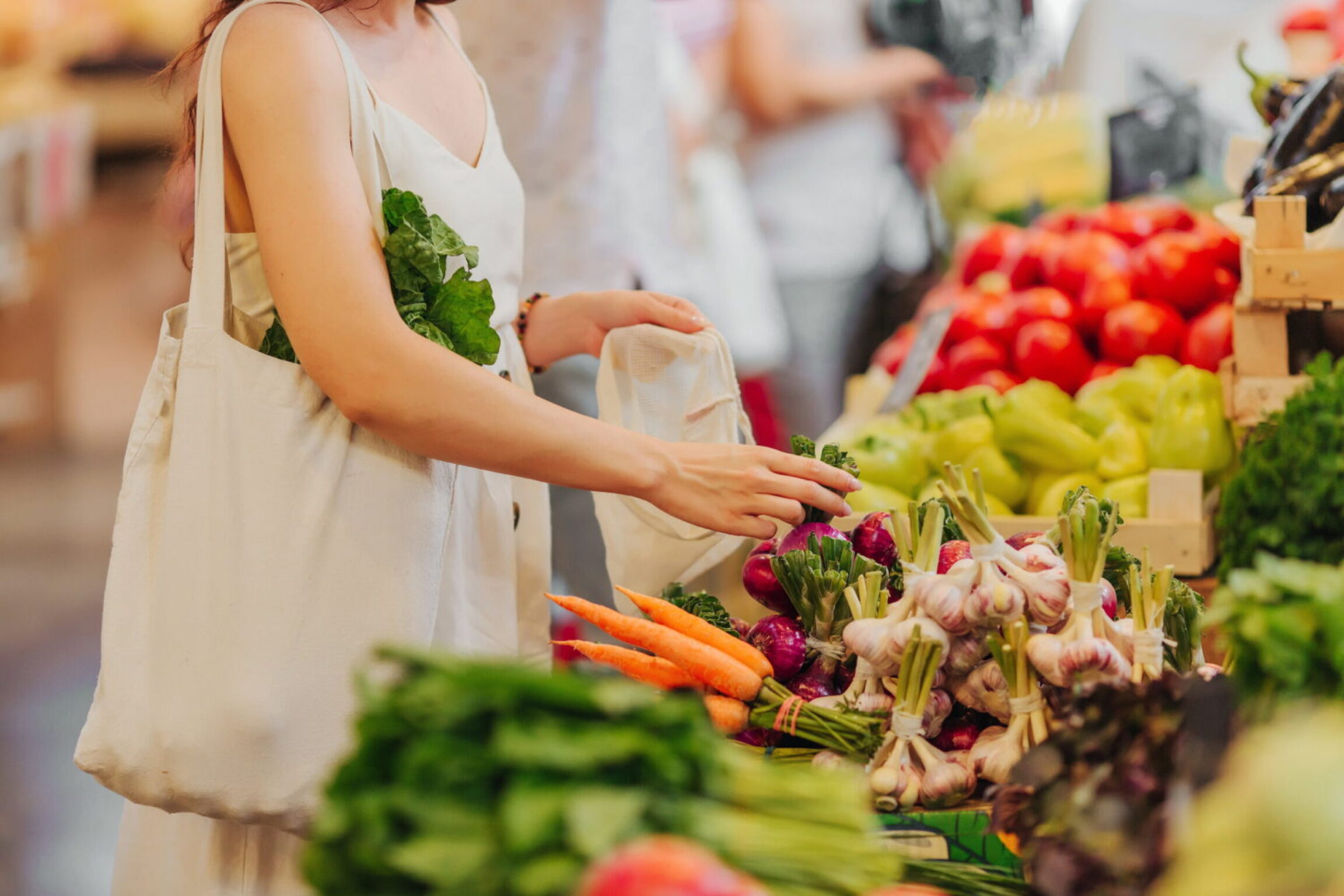A younger woman picking out heart-healthy foods from a local market