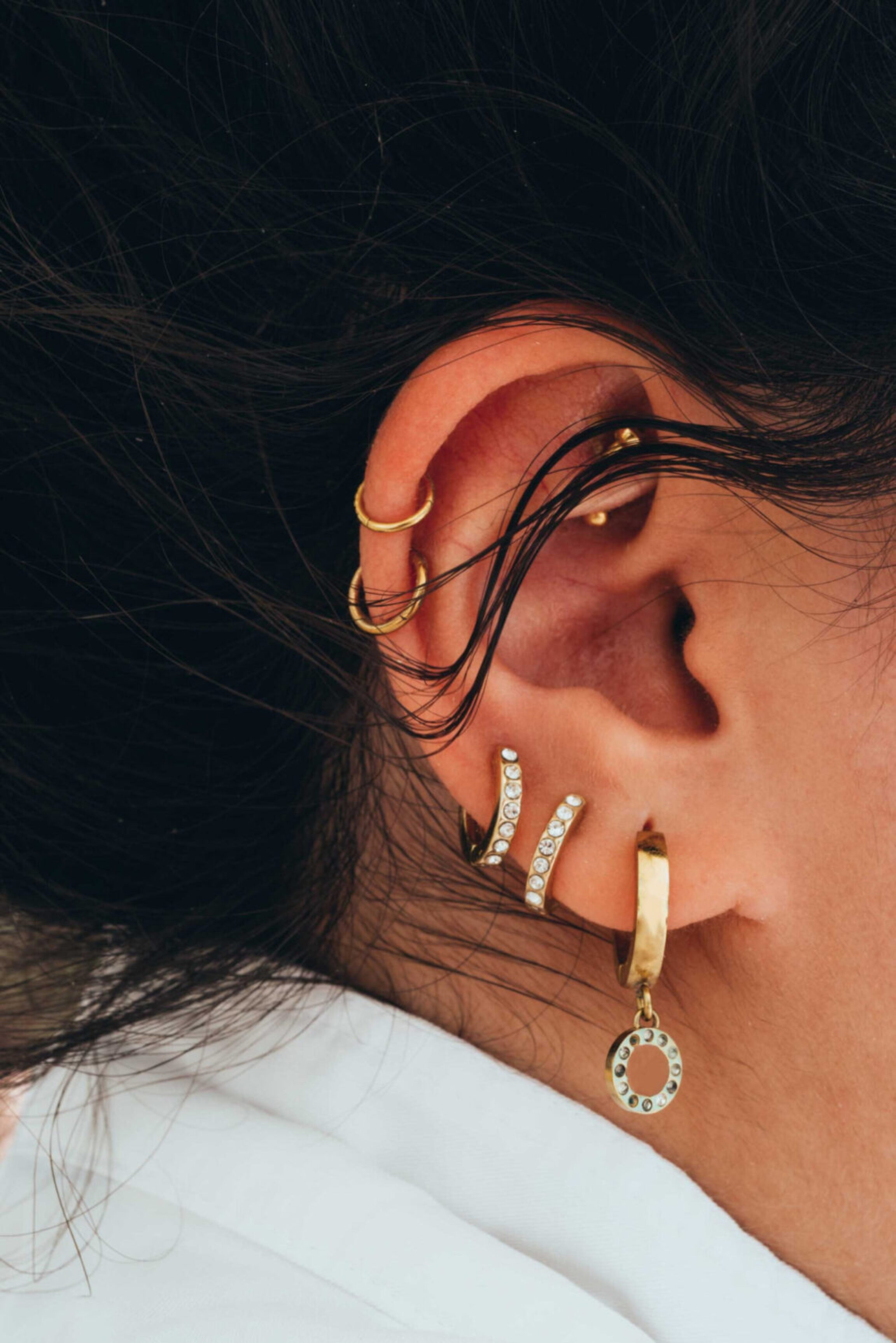 An up-close photo showcasing an woman's ear with multiple ear piercing placements