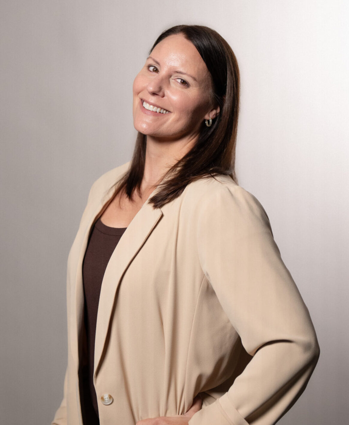Tricia Granchi, MSN, smiling confidently while posing against a muted backgrop