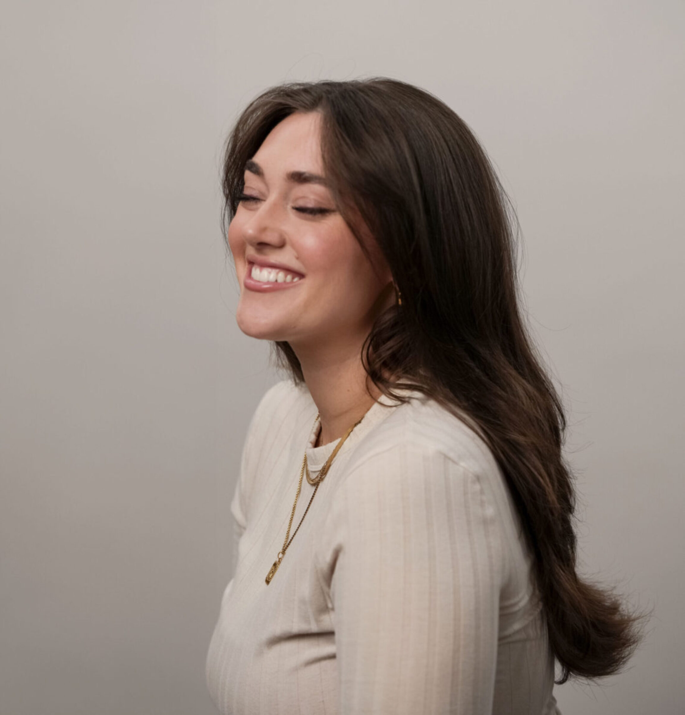 Andie Schroeder, LME, smiling while posing for a photograph against the muted wall in Lewis Center, Ohio