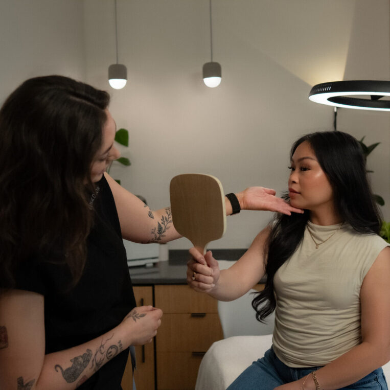 Andie helping a patient see what she could expect from specific ear piercing placements