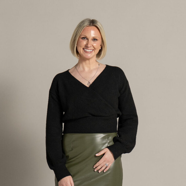 Functional medicine dietitian Colleen Bush, RDN, posing against a muted backdrop
